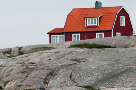Rött hus på granitklippor.
