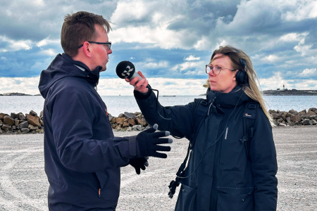 reporter från sveriges radio håller fram mikrofon till man