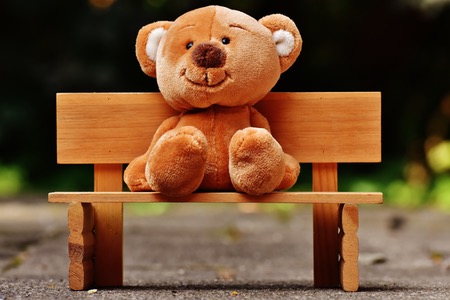 Nallebjörn som sitter på en parkbänk.
